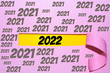 New year 2022 and pink Torn paper sheet on yellow background.
