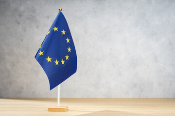European Union table flag on white textured wall. Copy space for text, designs or drawings