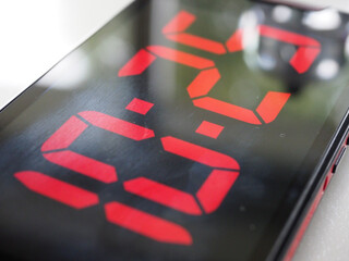 Close-up of a mobile phone screen with the display showing a digital time readout