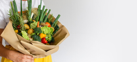 Close-up photo of woman holding fresh vegetables decorated into a bouquet.