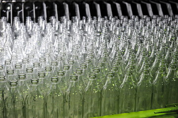 Glass bottles are on the conveyor for filling drinks