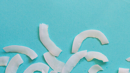 Background of dried coconut white chips on a blue background
