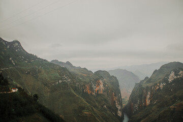 Beautiful view of the green mountains covered by mist. Dong Van Karst Plateau Geopark, Vietnam. - obrazy, fototapety, plakaty