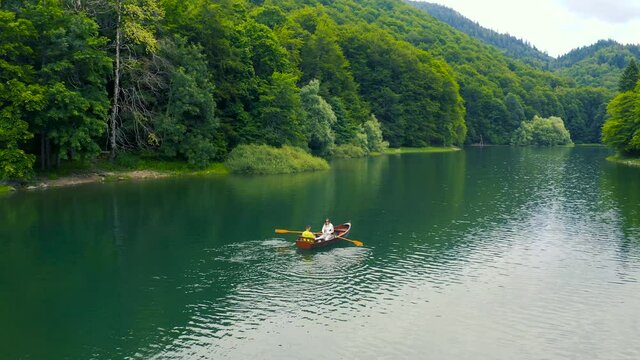 Young couple in a boat on the Biogradsko Lake in Montenegro. Aerial view 4K.
