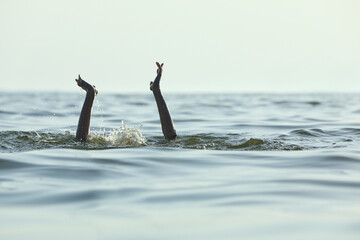 Fototapeta premium Drowning woman reaching for help in sea