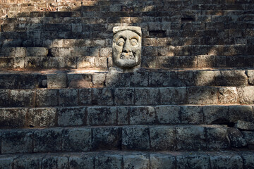Stone head carved from stone in ancient Mayan city of Copan in Honduras. Mayan symbol - a statue...
