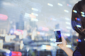 Double exposure of technology sketch hologram and woman holding and using a mobile device.