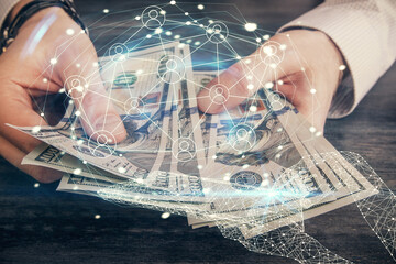 Multi exposure of social network theme drawing hologram and USA dollars bills and man hands.