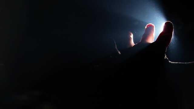 Man pulling his hand towards the light 