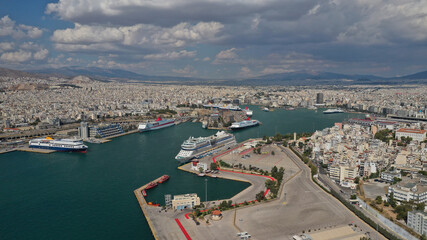 Fototapeta premium Aerial drone photo of famous busy port of Piraeus where passenger ferries travel to popular Aegean island destinations on a cloudy beautiful day, Attica, Greece