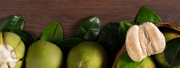 Fresh pomelo fruit on dark wooden table background.