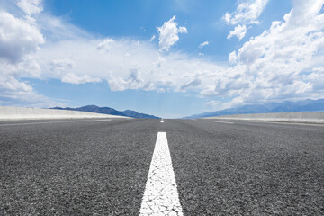 Straight highway and mountain natural scenery under blue sky.Landscape and highway.Outdoor road background. © ABCDstock