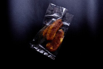 Dry banana in brown dryer isolated on black background. White banana sweet snack for nutrition. Solar energy and zero waste concept. Banana dry fruits isolated on black background.