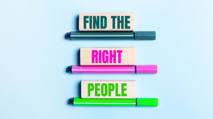 On a light blue background, there are three multi-colored felt-tip pens and wooden blocks with the FIND THE RIGHT PEOPLE