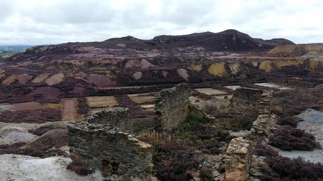 Parys mountain rocky copper mining stone ruin excavation quarry aerial rising view Anglesey mine Wales UK