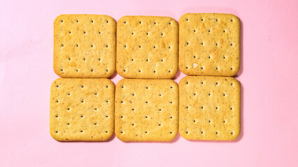Cookie cracker close-up on a pink background.
