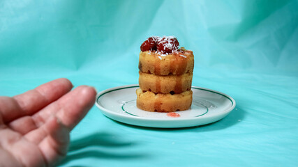 Soft waffles on a saucer, poured with strawberry jam with berries and sprinkled with coconut shavings.