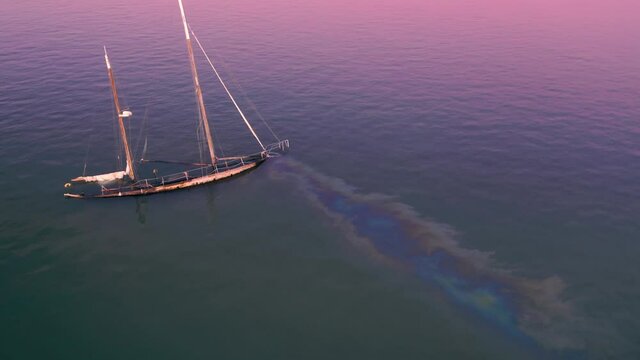 Aerial: Sunken yacht in the water at sunset. San Pablo Bay, Oakland, USA