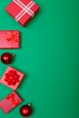 Composition of presents with bauble and copy space on green background