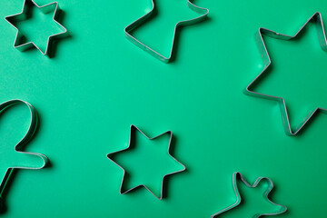 Composition of stars and angels ginger man cookie cutters on green background