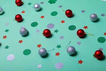 Composition of christmas decorations with baubles and stars on green background