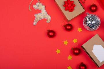 Composition of christmas decorations with baubles, presents and copy space on red background