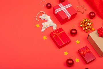 Composition of christmas decorations with baubles, presents and copy space on red background