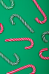 Composition of multiple green and red candy canes on green background
