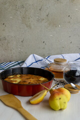 Homemade pear pie on a white table with pears in the foreground