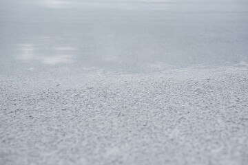 Close up of a dried, crystallised, cracked, natural white salt lake bed on a sunny day.