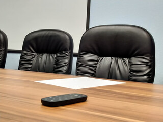 Black business chairs on the background of a white screen in the negotiation office with a remote...