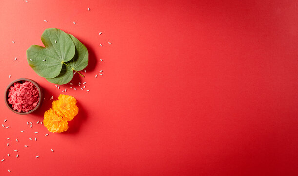 Happy Dussehra. Yellow flowers, green leaf and rice on red background. Dussehra Indian Festival concept.