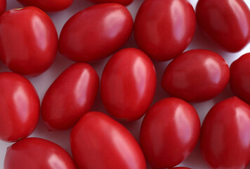 Lots of red conical tomatoes on a white background, fresh harvest, top view