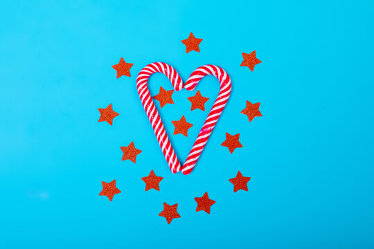 Composition of candy canes with red stars on blue background