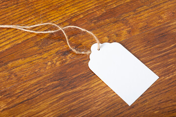 Composition of white label card with copy space on wooden background