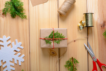 Composition of christmas decorations with present, ribbon, and scissors on wooden background