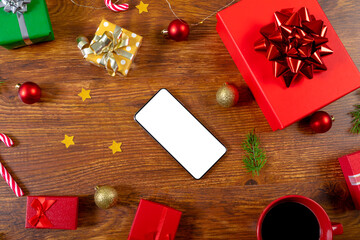 Composition of smartphone with copy space and christmas decorations on wooden background