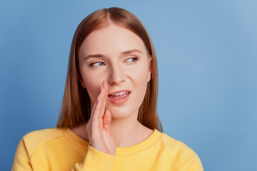Portrait of cunning sly gossip lady palm mouth look side empty space on blue background