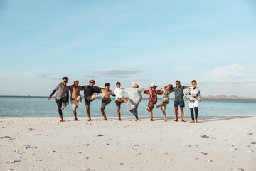 Group of happy Asian friends enjoying vacation with embrace each other and dance on the beach