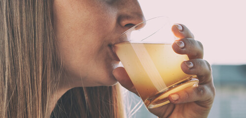 Woman is drinking dirty water from the glass cup