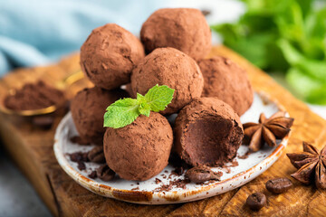 Chocolate truffles on a plate. One truffle missing a bite. Selective focus