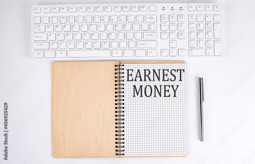 Poster earnest money text on the notebook with keyboard on white background