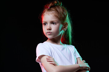 proud redhead little child girl on black background.