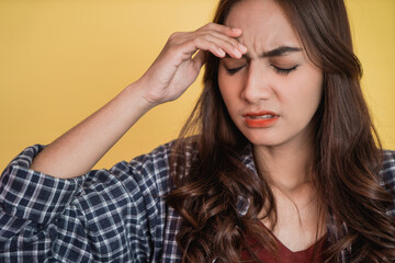 Naklejka premium close up of an asian woman holding head with hands when dizzy