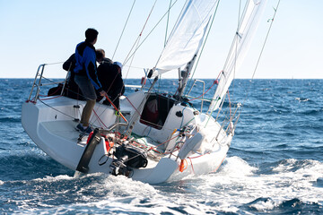 Obraz premium Silhouette of sailing crew on sailboat during regatta