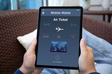 male hands holding computer tablet with airplane ticket application airlines