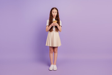 Portrait of pretty girl hold cellphone look screen open mouth funny face on purple background