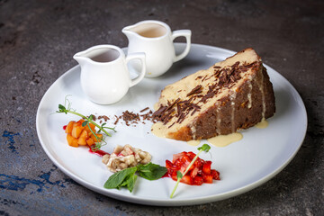 honey cake with chocolate chips and berries in a cafe on a white plate