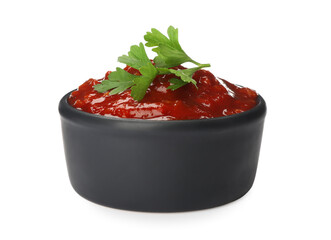 Delicious adjika sauce and parsley in bowl isolated on white