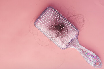 a brush with lost hair on pink background
